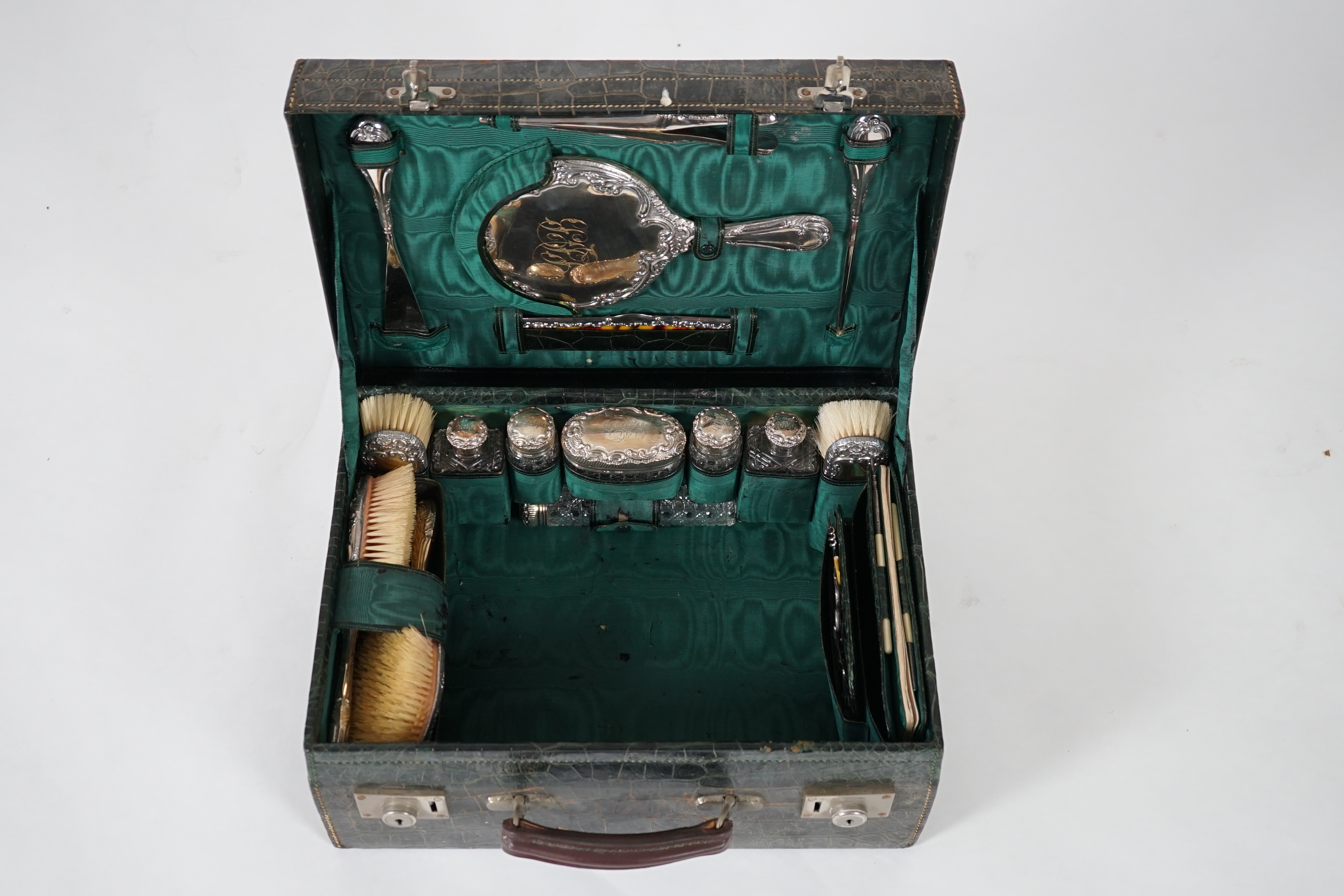 A George V green crocodile toilet case, 46cm x 33cm x 18cm